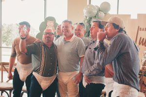 Group of guests laughing and drinking together at a festive celebration.