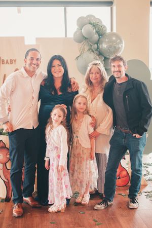 Family gathering at baby shower with elegant balloon decorations and vintage fox theme.