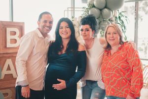 Family members gather for group photos in a bright indoor space with festive decorations.