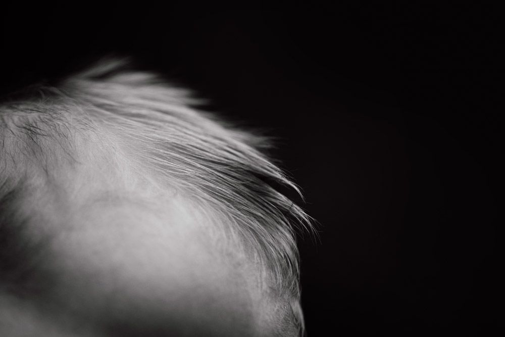 Artistic macro shot of soft baby hair against dark background.