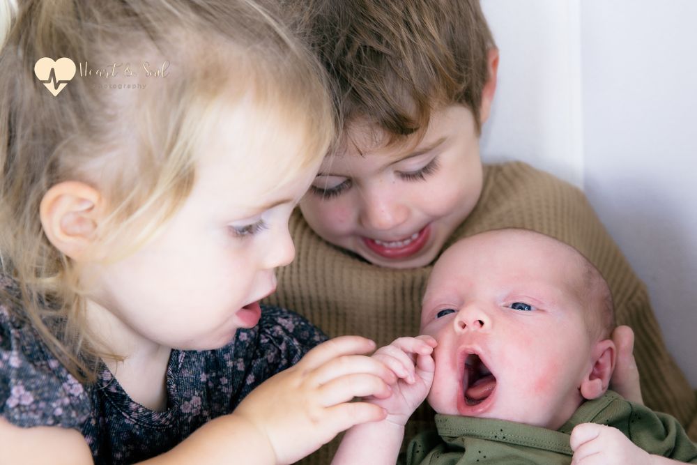 two kids holding baby and holding hands