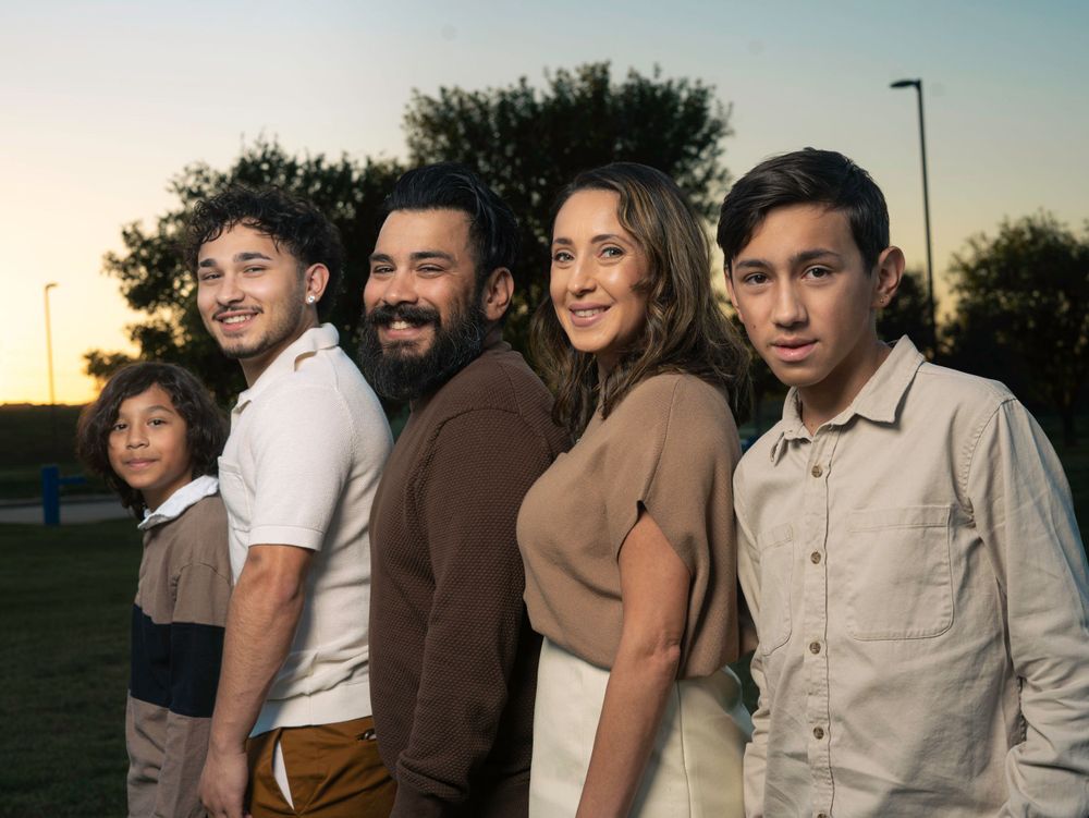 A group poses together in coordinated earth-tone outfits during golden hour outdoors.