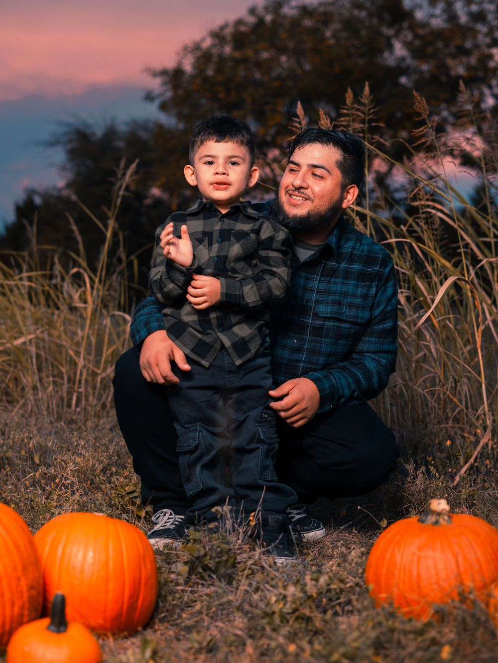 Fall pumpkin portrait session featuring plaid flannel and orange pumpkins at sunset.