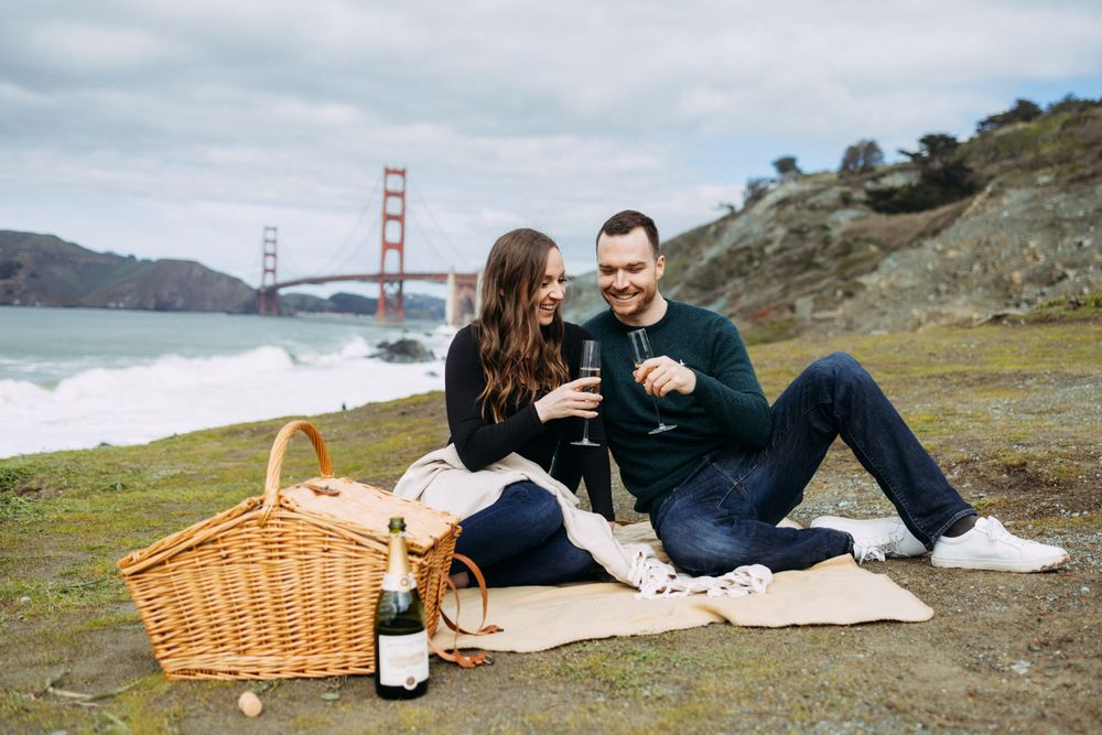 Champagne toast during engagement photos with Golden Gate Bridge