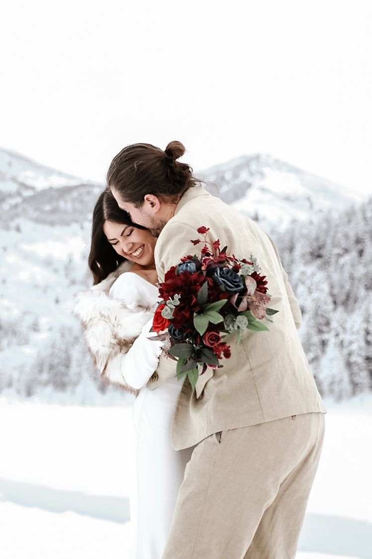 intimate elopement photo of a couple surrounded by snow-covered Wyoming mountains