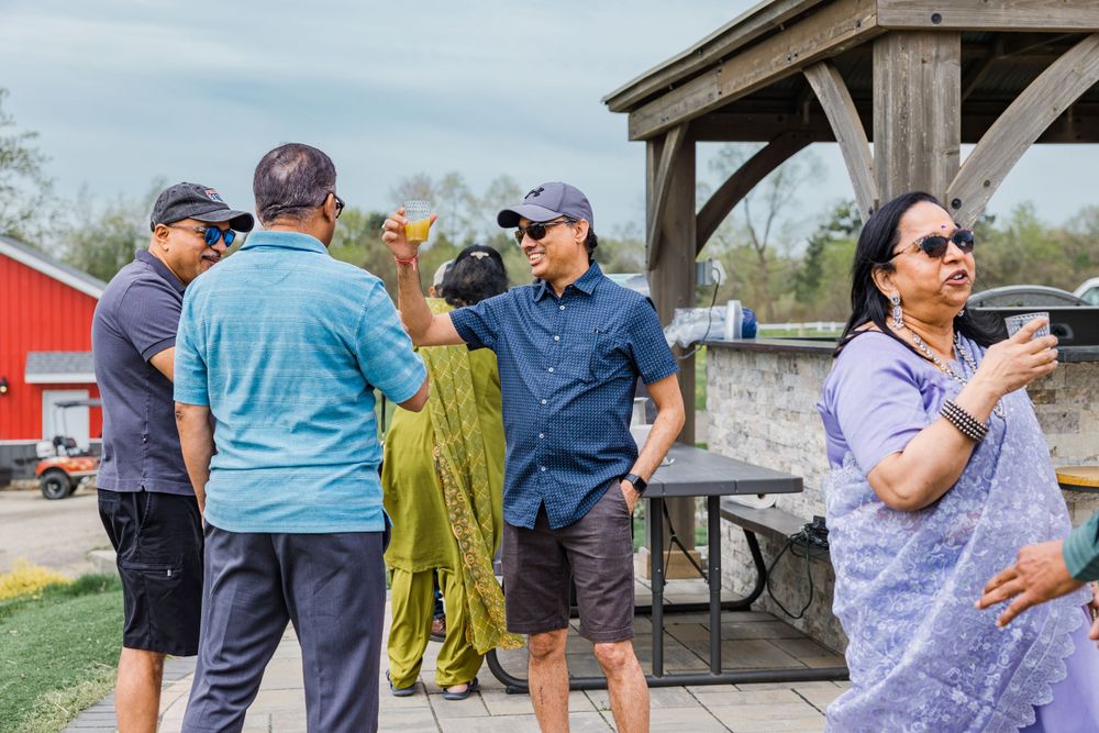 People socializing under a wooden pavilion at an outdoor event.
