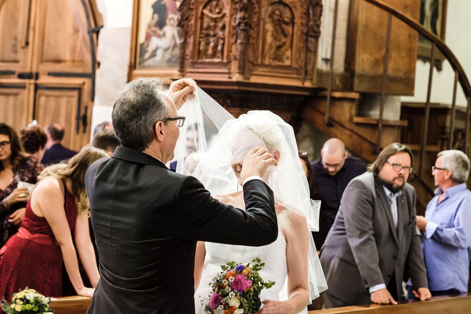 TLOOK photographe de mariage de style documentaire, cérémonie religieuse église à sion le marié enlève le voile