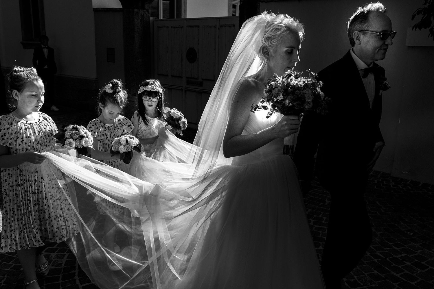 TLOOK photographe de mariage de style documentaire, cérémonie à sion les filles tiennent la robe de la mariée