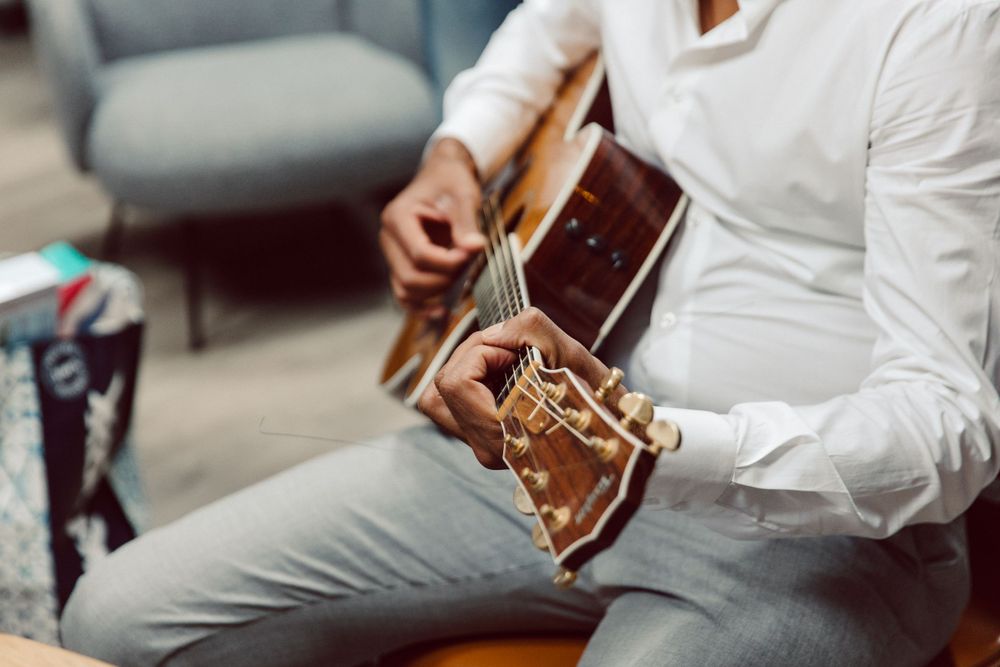 Musicians playing acoustic guitar in formal attire.