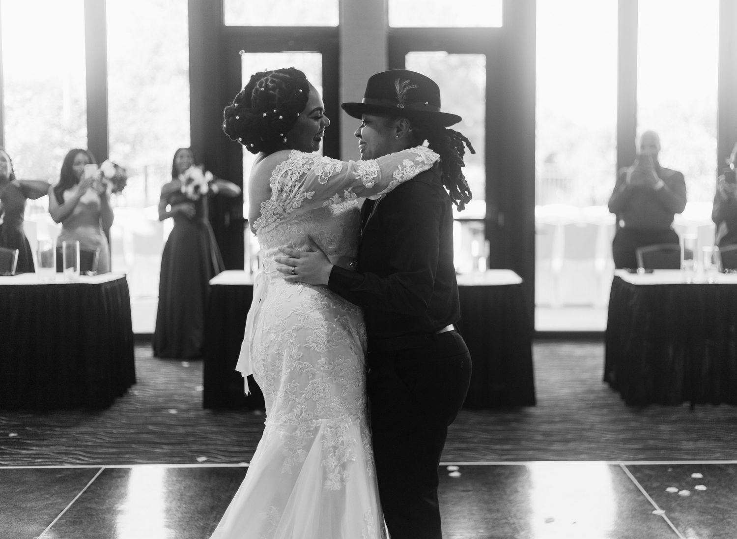 Black and white photo of couple sharing first dance at wedding reception.