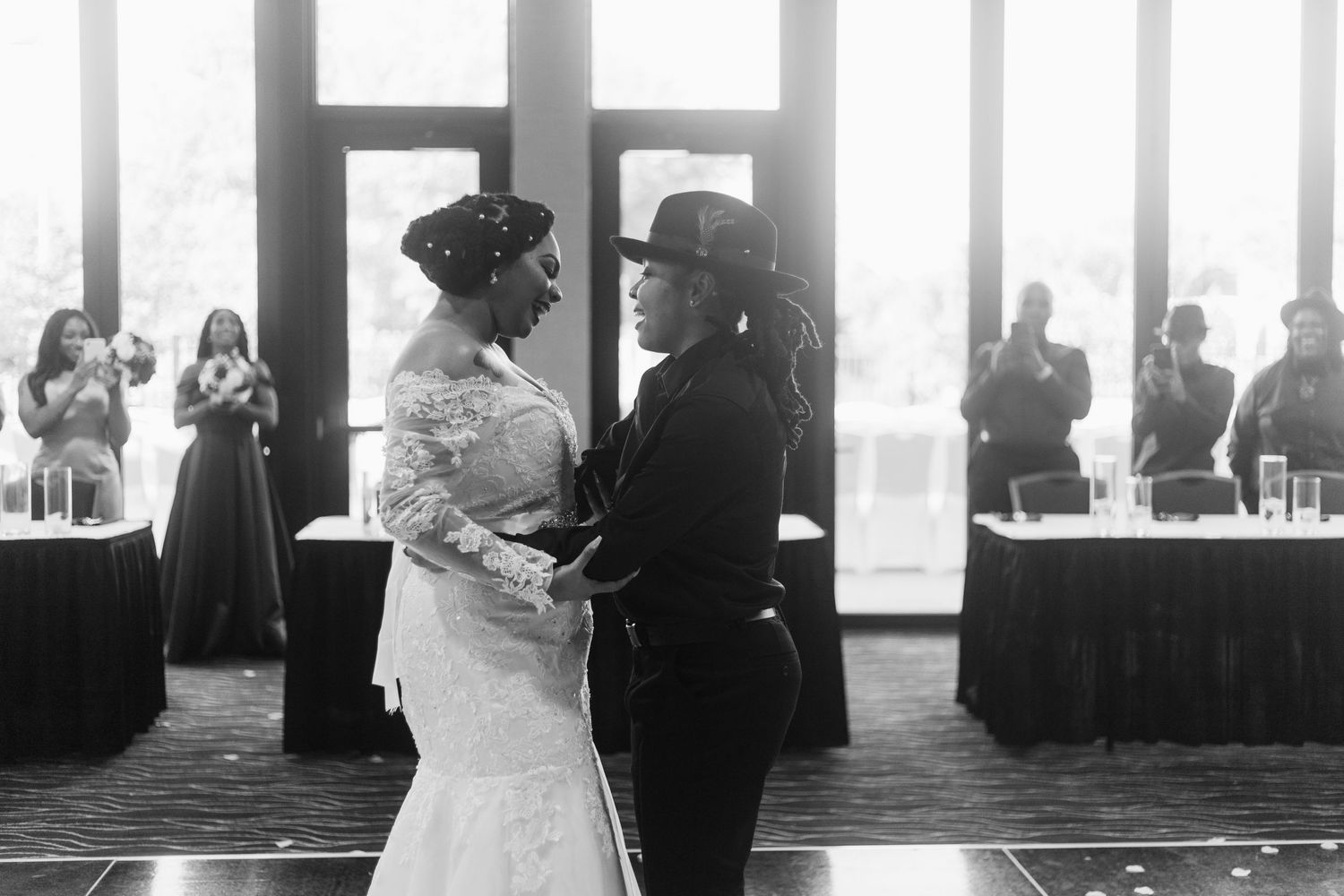 Couple dancing together at wedding reception in elegant black and white photo.
