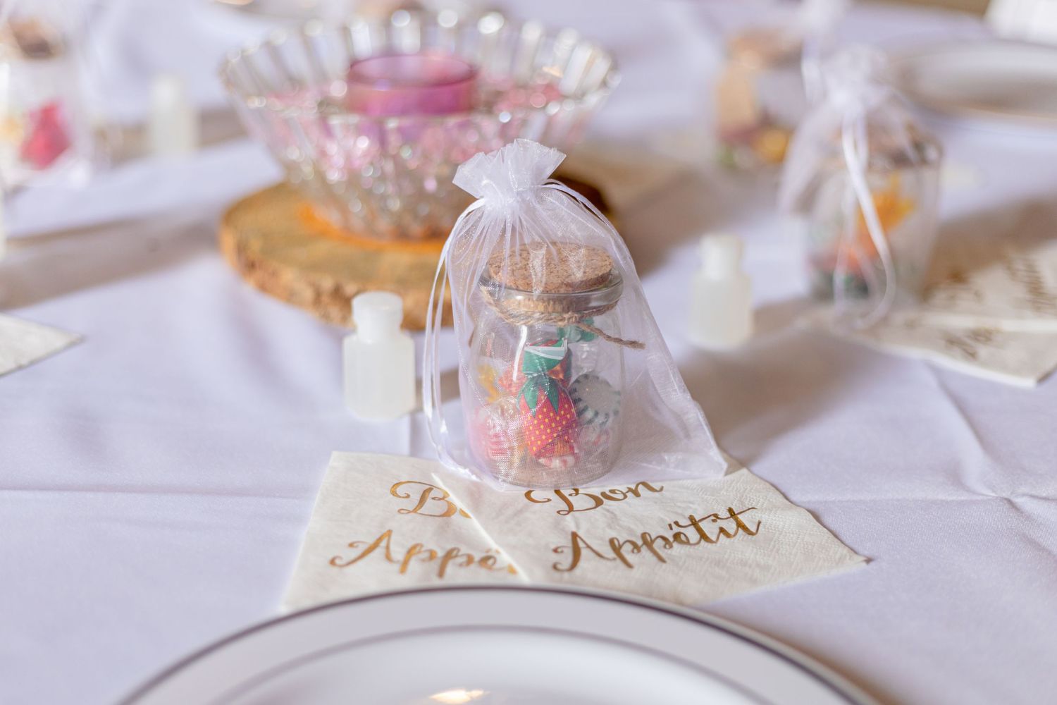 Elegant wedding reception table with organza favor bags and Bon Appetit napkins.