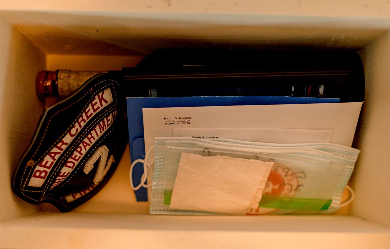 Cluttered shelf with Bear Creek hat, envelopes, and personal items stored inside.