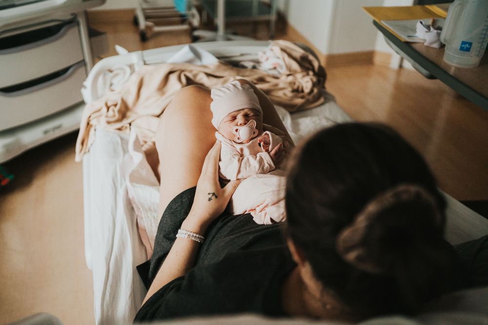 Candid lifestyle photography of baby lying on blanket during indoor newborn photoshoot.