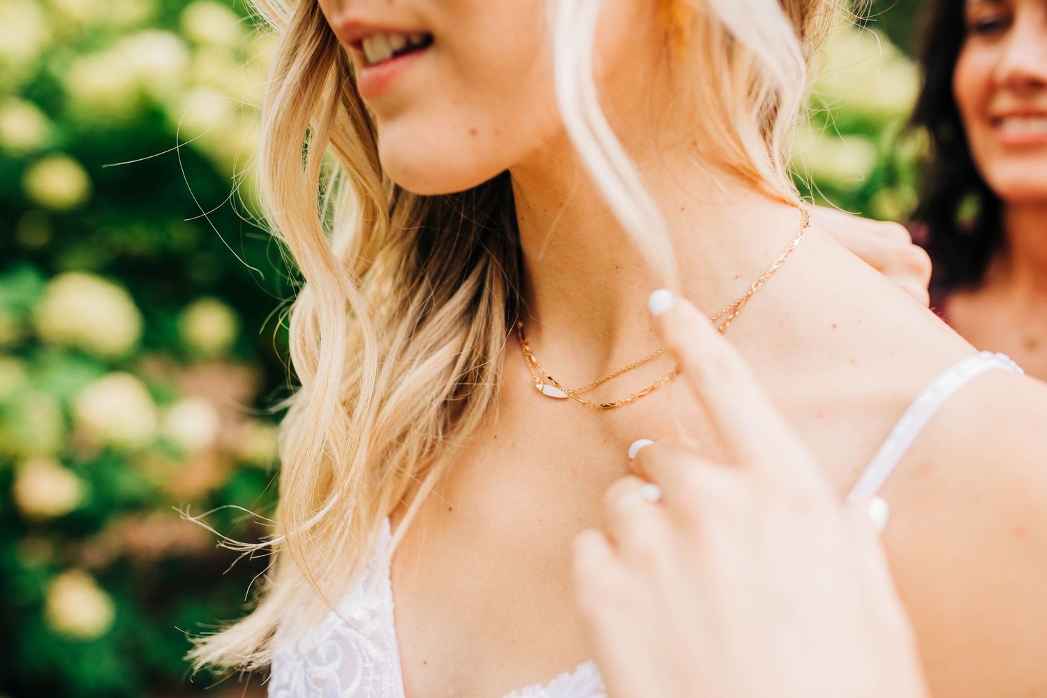 Close-up detail of delicate lace wedding dress and jewelry.