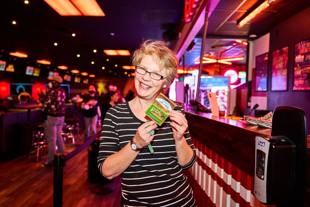 A youth in a striped shirt enjoying a snack at a colorful restaurant counter.