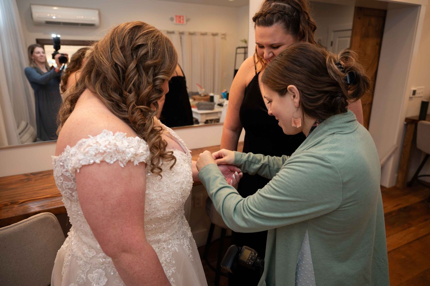 Wedding dress adjustments being made as final preparations take place indoors.