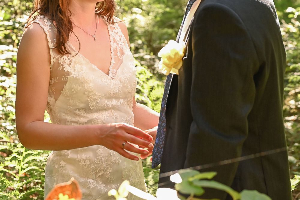Cropped photo of bride and groom in forest.