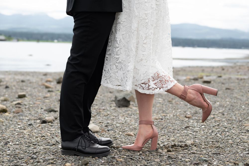 Bride and grooms feet on pebble beach.