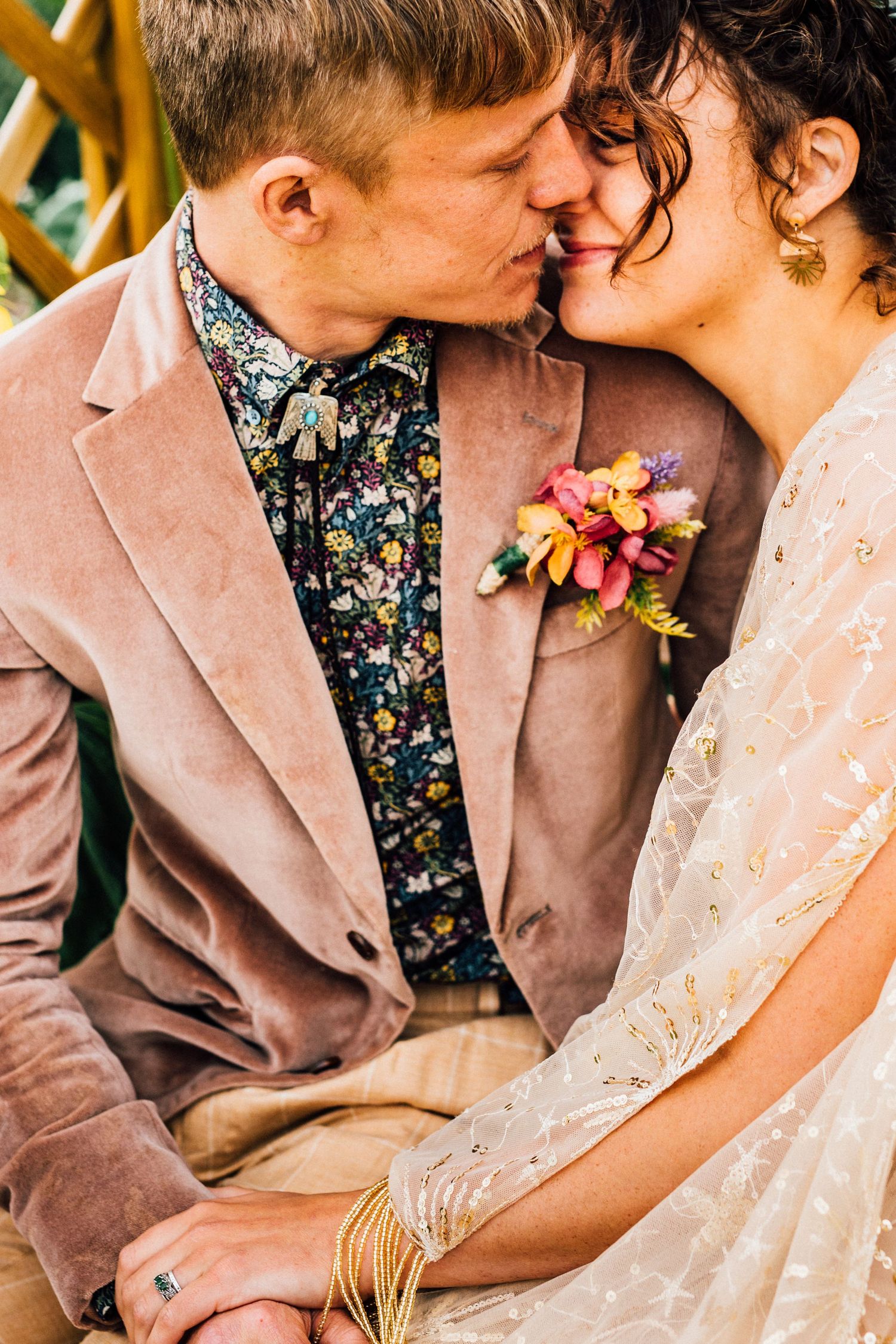 Close-up of couple sharing intimate moment while wearing vintage-inspired wedding attire.