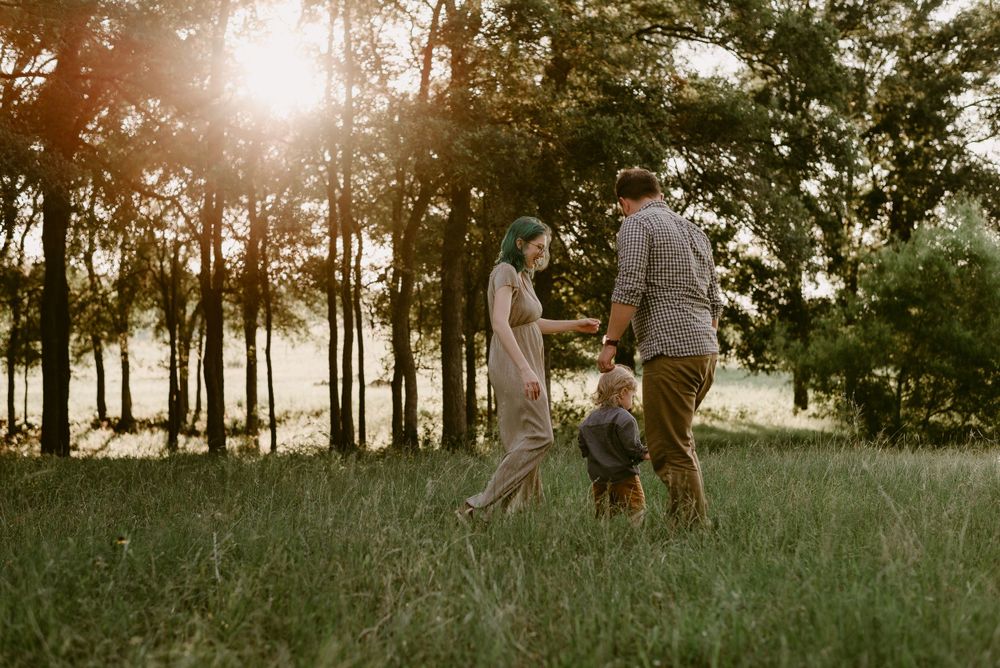 Family spending quality time together in grassy field during golden hour.