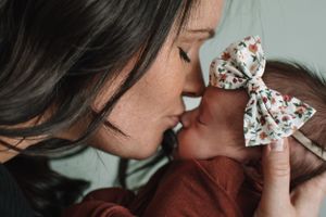 Intimate moment of tender care and affection with floral bow accent.
