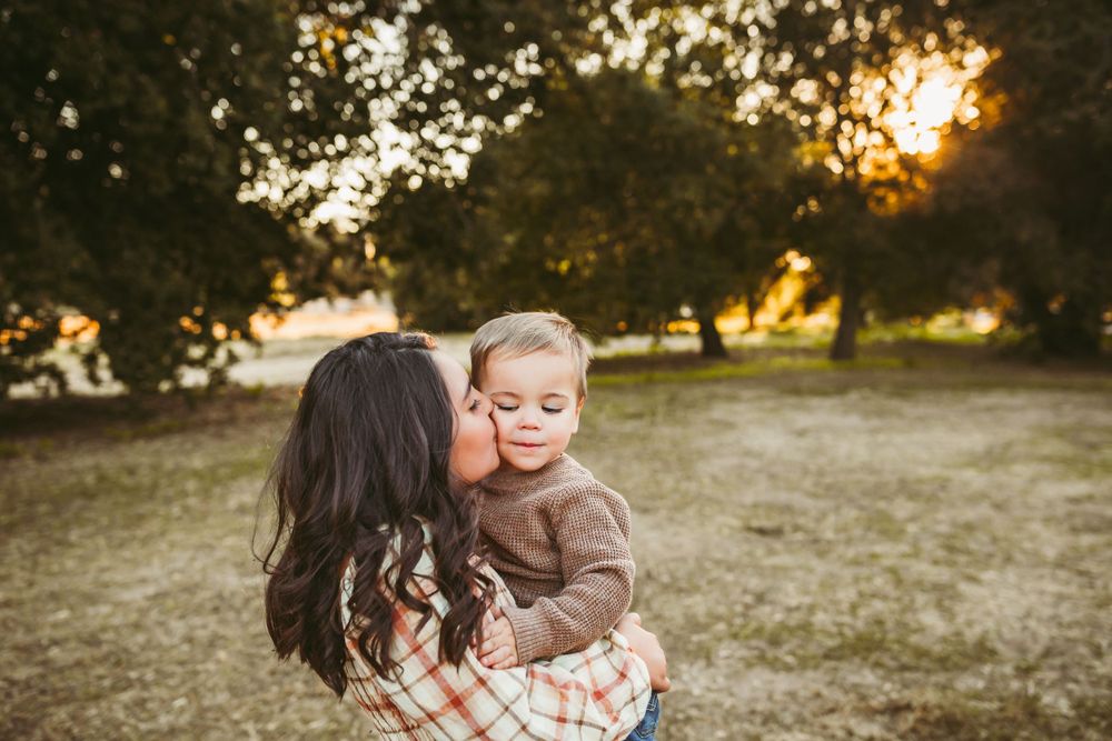 big sister kisses little brothers check during a photo session in yucaipa ca