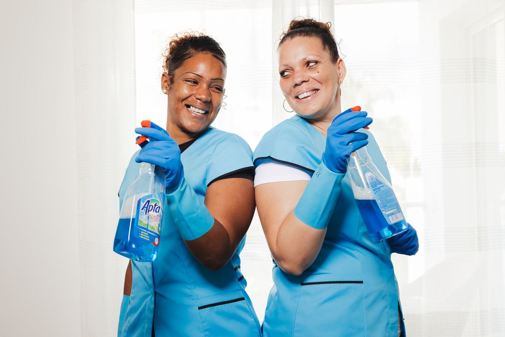 Medical professionals in blue scrubs working together in bright clinical setting.