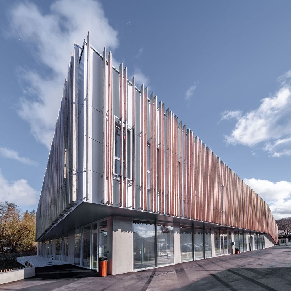 Modern commercial building with vertical metal slats creating a striking architectural pattern.