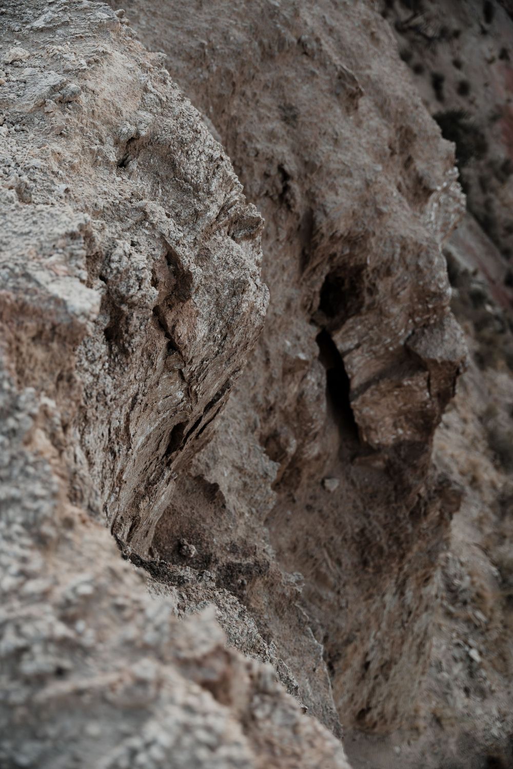 Close up texture of rough limestone rock formation with deep crevices.