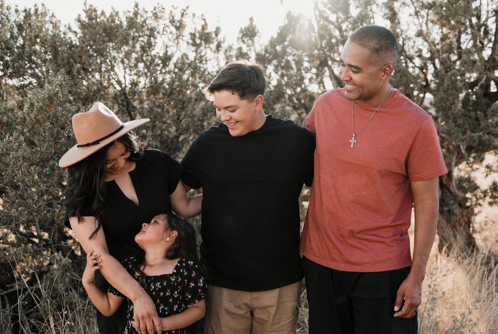 Family group photo with desert brush and warm sunset lighting.