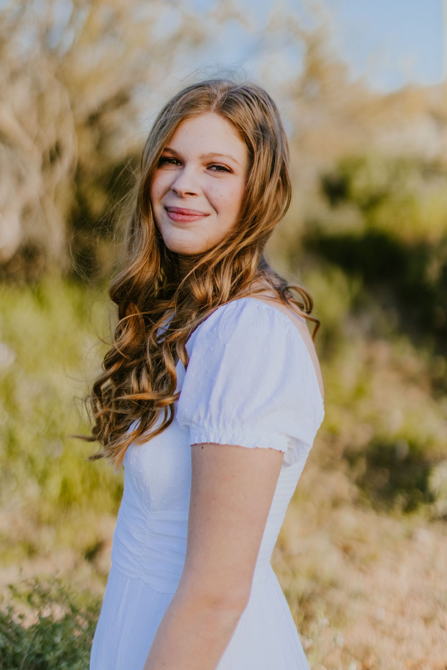 Desert portrait session with mountains and cacti creating a scenic natural backdrop.