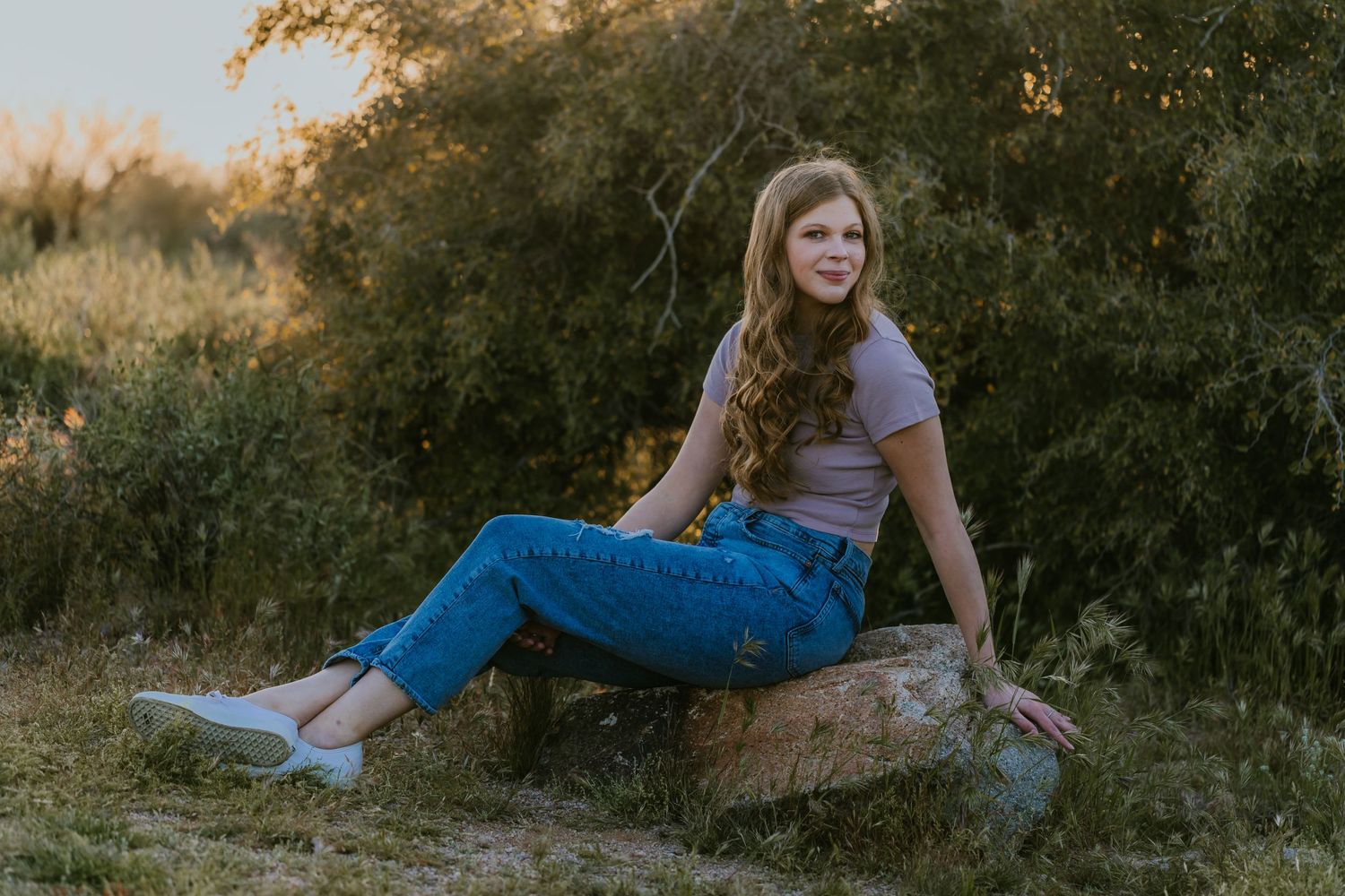 Natural outdoor portrait featuring casual pose on rocky terrain.