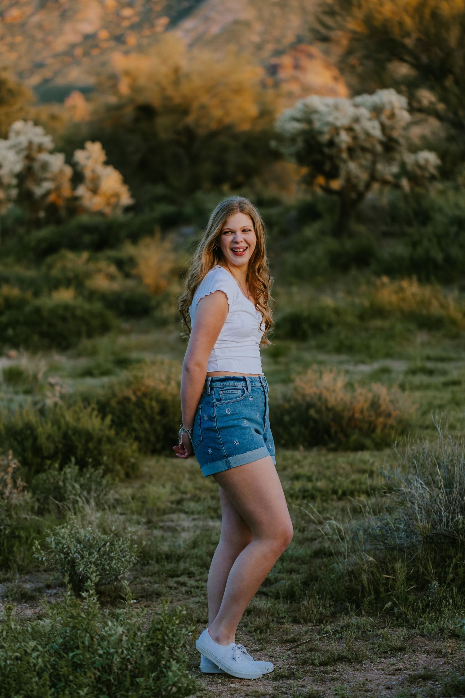 Casual outdoor portrait in natural desert setting during golden hour.