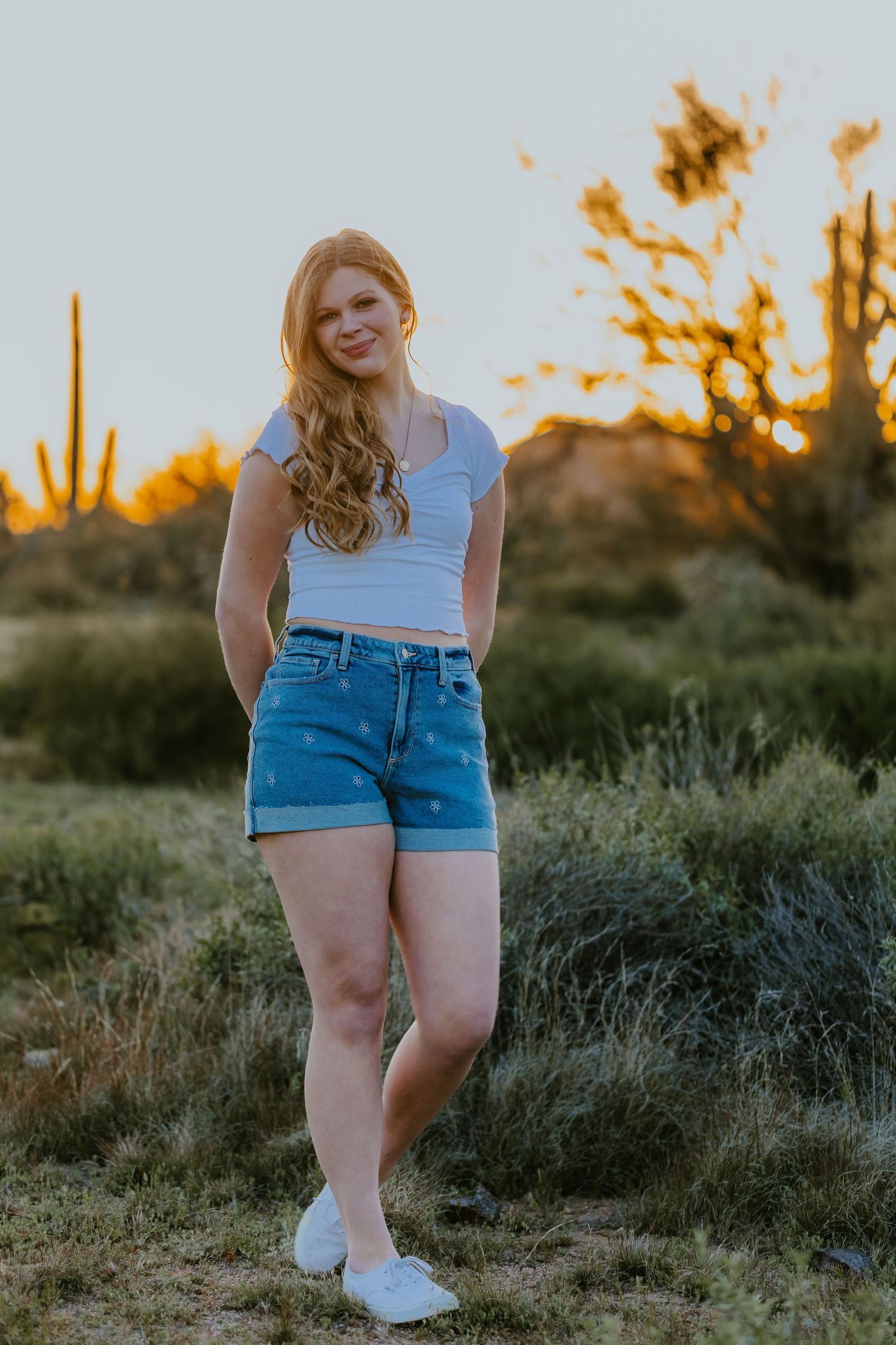 Natural desert portrait featuring casual outfit with saguaro cactus silhouettes at sunset.