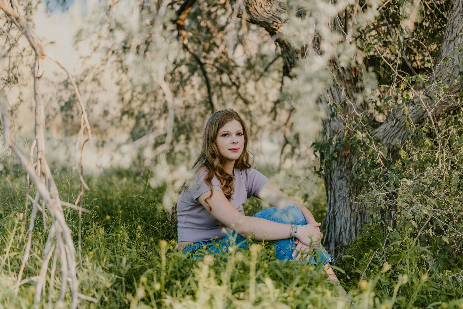 Outdoor portrait session with dreamy lighting and natural foliage backdrop.