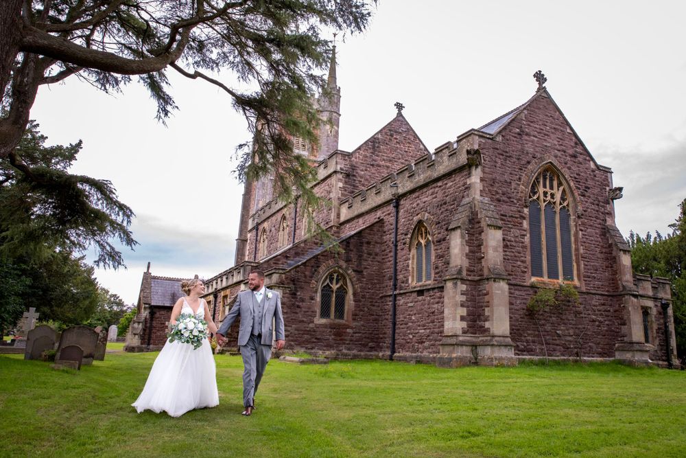 Bride and groom by church. Couple shot casual walking.