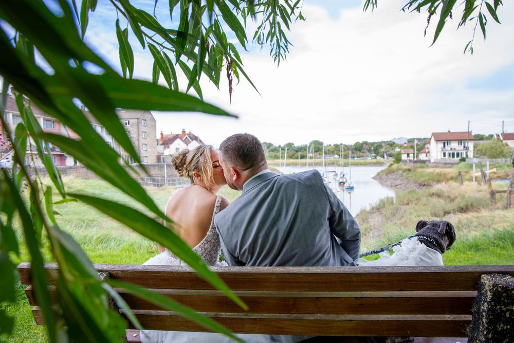 Bride and groom kissing by river creek.