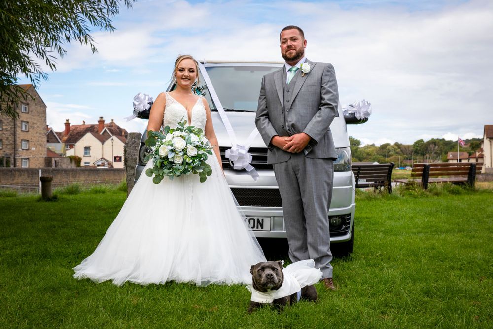 Bride, groom and pet dog posing by VW van.