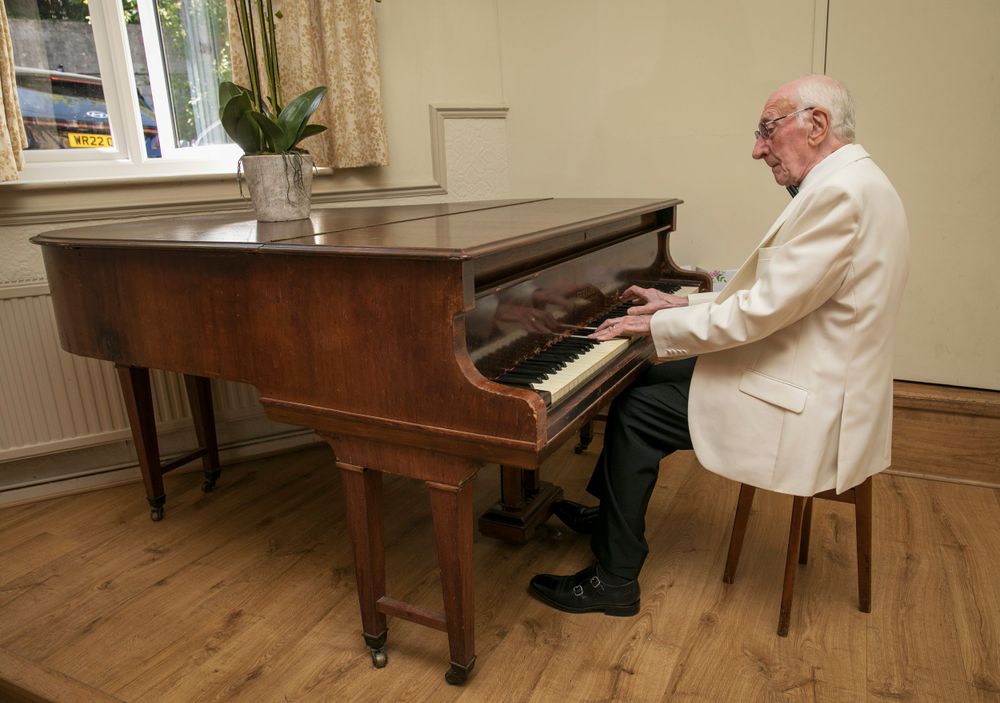 Pianist playing on grand piano during ceremony.