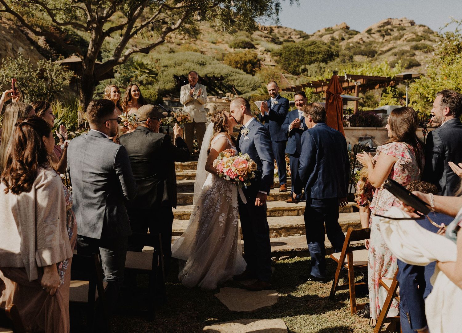 E Noelle Photography backyard wedding in Hidden Hills Los Angeles, bride and groom kiss at end of aisle