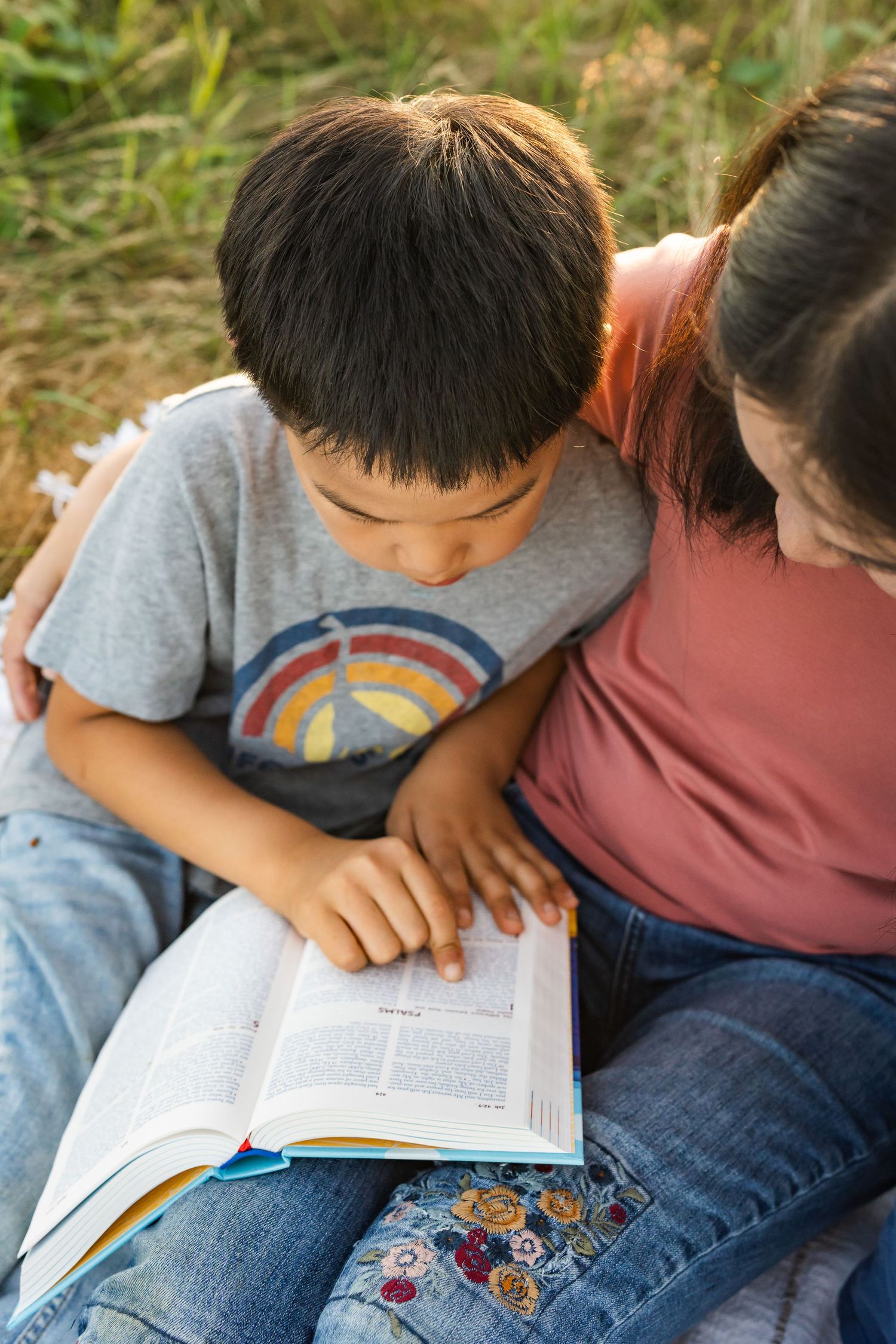 Child reading the bible to his mother during family photos