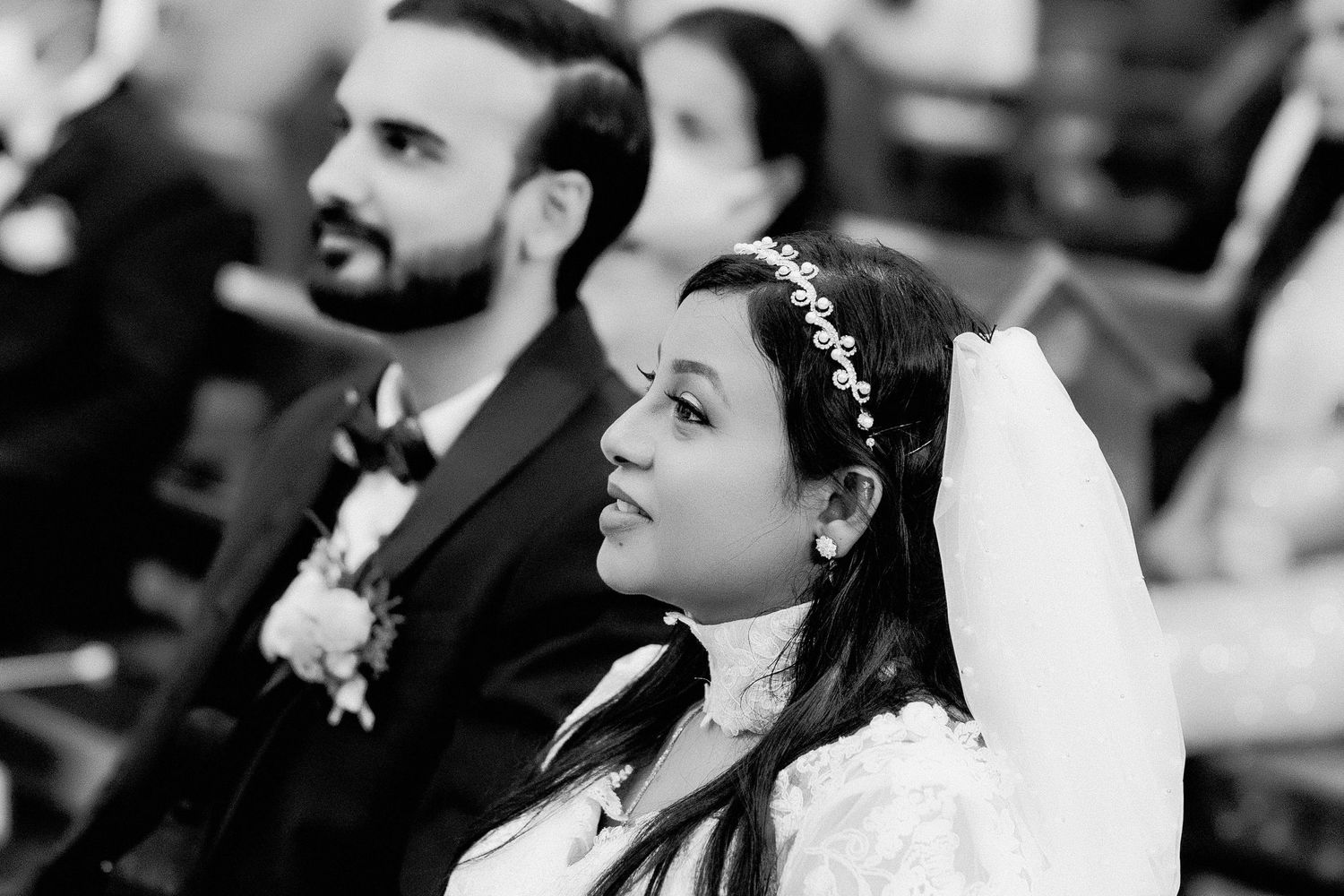 Black and white photo of a traditional church wedding ceremony with guests seated in wooden pews.