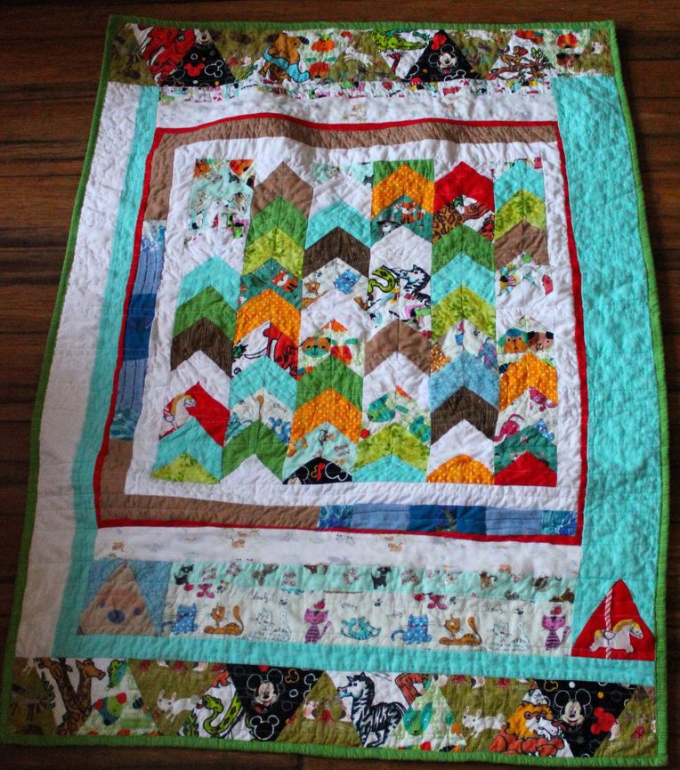 A custom herringbone 'Love Quilt' made from fabrics from family and friends as a gift for a new baby.