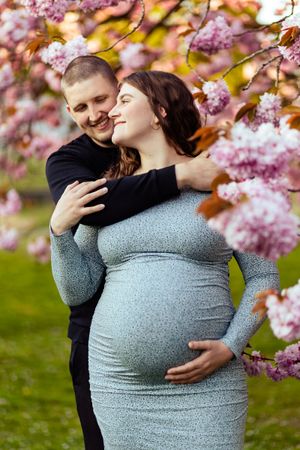 En gravid kvinde og hendes mand under et blomstertræ på Borgvold i Viborg