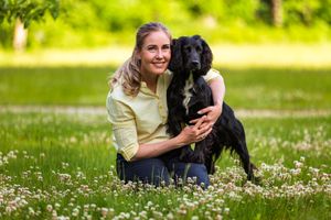 En kvinde med sin hund i en blomstereng ved Hald Hovedgård i Dollerup Bakker i Viborg