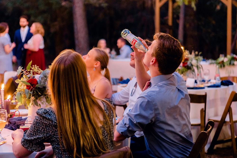 Wedding guests enjoying drinks and conversation at an outdoor reception.