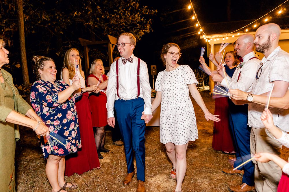 Wedding guests dancing at an outdoor reception under string lights.