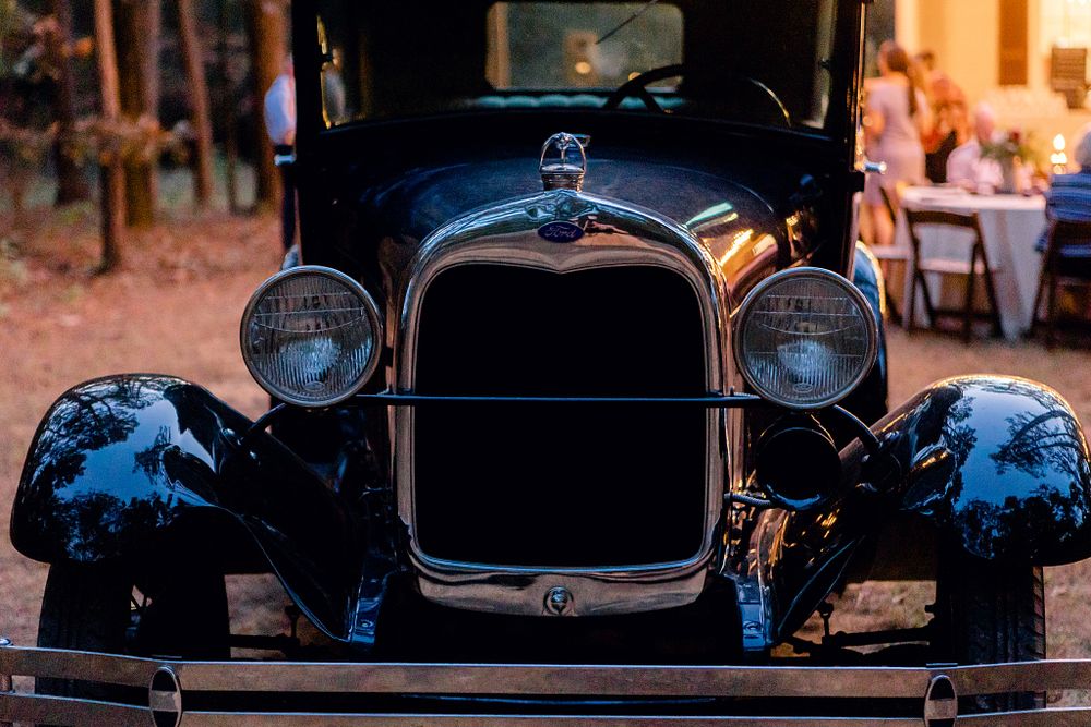 Front view of a classic black Ford Model A car at dusk.