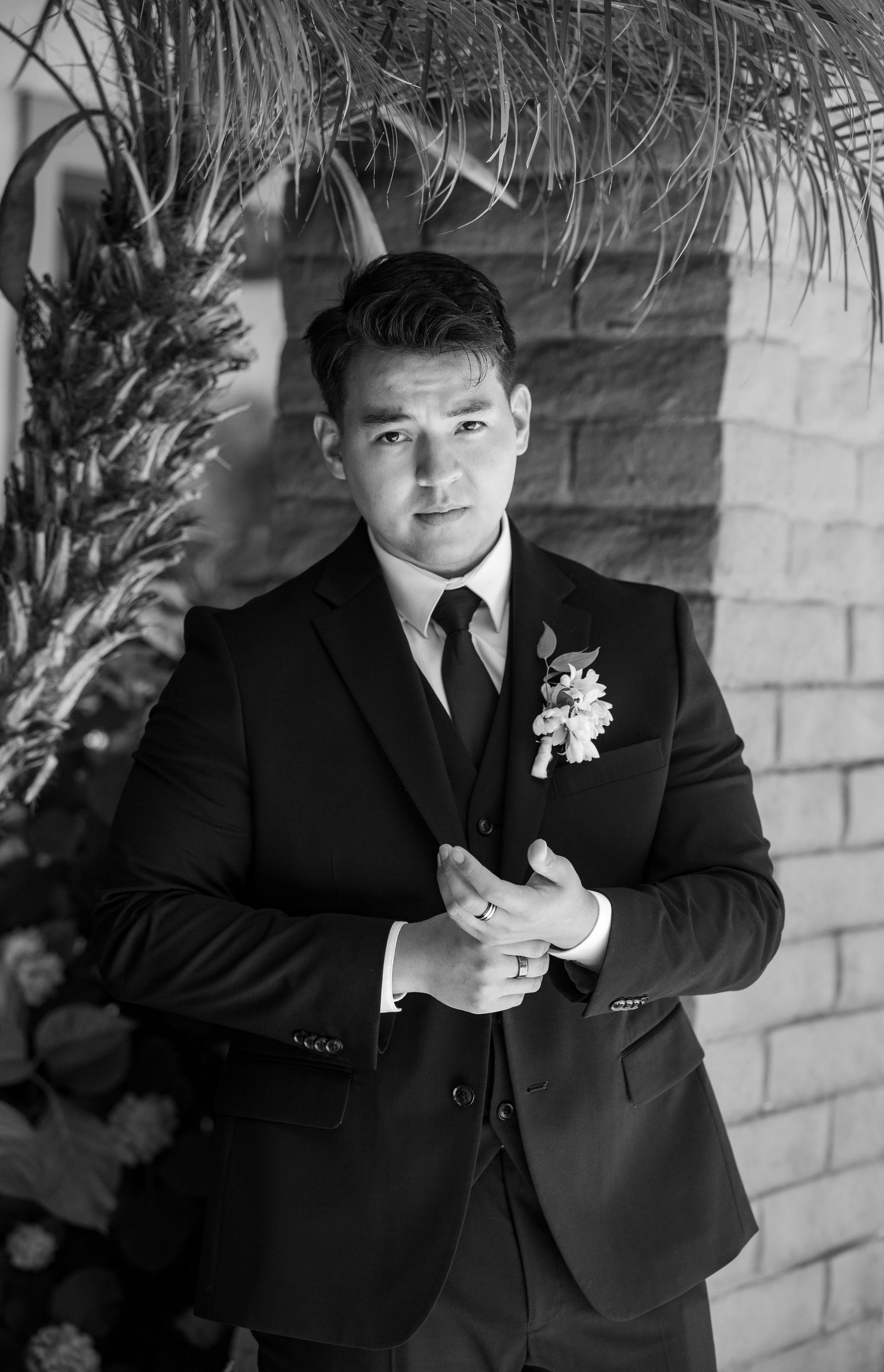 Classic black and white portrait of groom in formal suit with boutonniere.